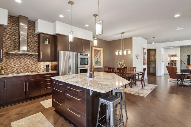 kitchen with tasteful backsplash, stainless steel appliances, dark wood finished floors, and wall chimney exhaust hood