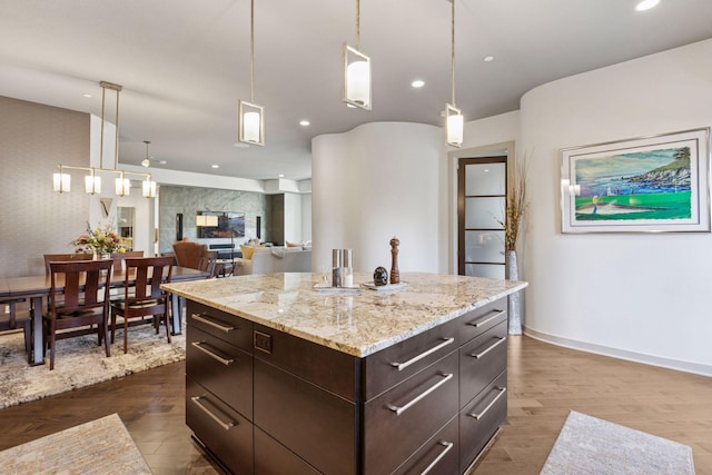 kitchen featuring recessed lighting, dark wood-style flooring, dark brown cabinetry, and hanging light fixtures