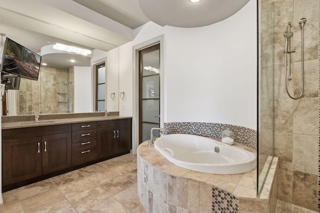 full bathroom with a sink, a tile shower, a garden tub, and double vanity