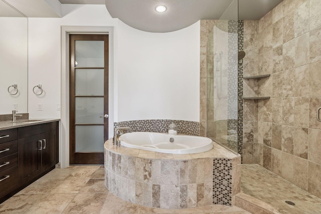 full bath with vanity, a bath, and a tile shower