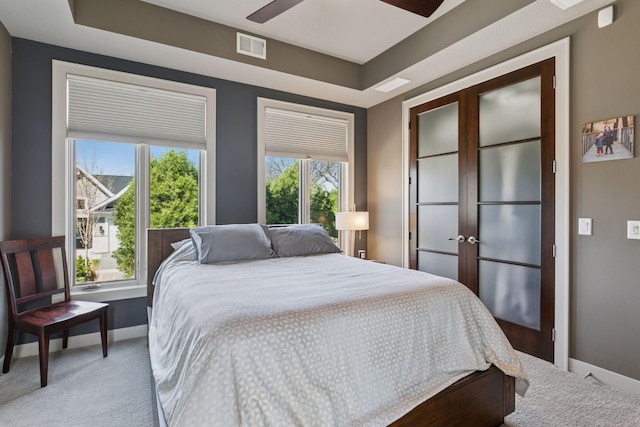 bedroom featuring baseboards, visible vents, and light carpet