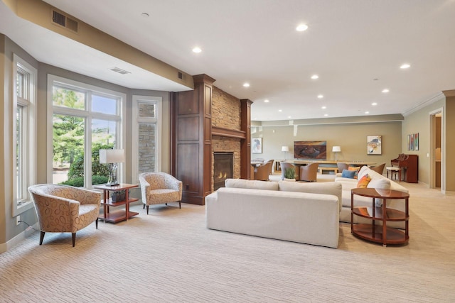 living room featuring light colored carpet, recessed lighting, a stone fireplace, and visible vents