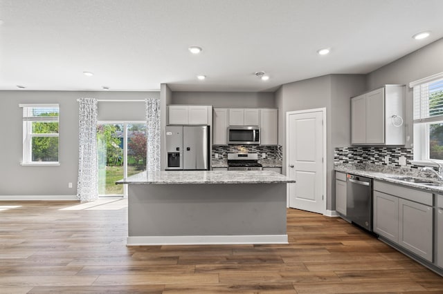 11263 131st Cir N, Dayton, MN 55327 - kitchen featuring appliances with stainless steel finishes, a sink, backsplash, a kitchen island, and recessed lighting