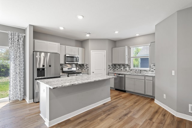 11263 131st Cir N, Dayton, MN 55327 - kitchen with appliances with stainless steel finishes, tasteful backsplash, a kitchen island, light wood finished floors, and recessed lighting