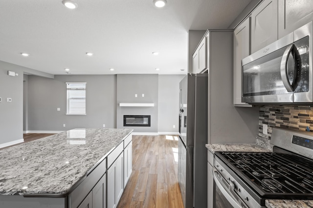 11263 131st Cir N, Dayton, MN 55327 - kitchen featuring appliances with stainless steel finishes, gray cabinets, light stone counters, light wood finished floors, and recessed lighting