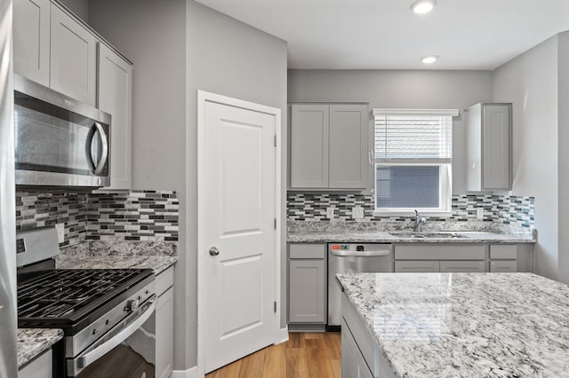 11263 131st Cir N, Dayton, MN 55327 - kitchen featuring appliances with stainless steel finishes, a sink, light wood-style flooring, tasteful backsplash, and recessed lighting