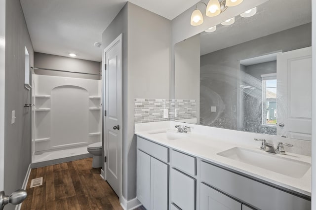 11263 131st Cir N, Dayton, MN 55327 - bathroom featuring wood finished floors, tasteful backsplash, a shower, double vanity, and toilet