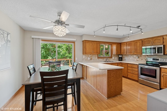 17150 Grenadier Ave, Lakeville, MN 55044 - kitchen featuring stainless steel appliances, a peninsula, light wood-type flooring, decorative backsplash, and a textured ceiling