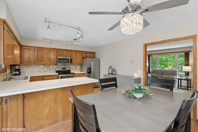 17150 Grenadier Ave, Lakeville, MN 55044 - kitchen with appliances with stainless steel finishes, a ceiling fan, a peninsula, light countertops, and tasteful backsplash