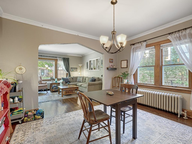 2100 Saint Clair Ave, Saint Paul, MN 55105 - dining area with radiator heating unit, arched walkways, ornamental molding, wood finished floors, and a chandelier