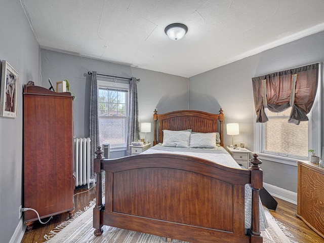 2100 Saint Clair Ave, Saint Paul, MN 55105 - bedroom featuring radiator, wood finished floors, and baseboards