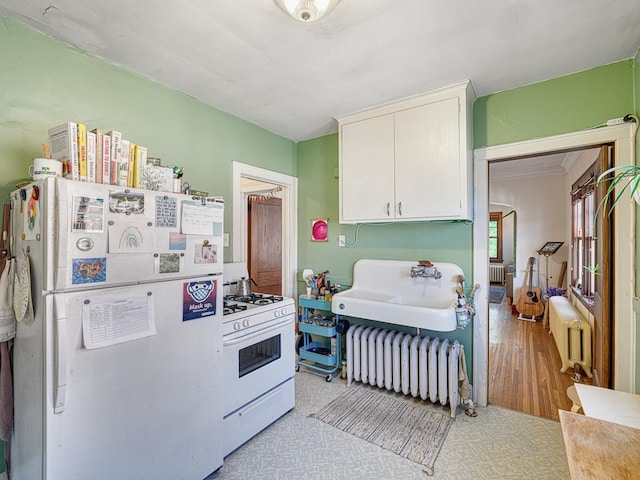 2100 Saint Clair Ave, Saint Paul, MN 55105 - kitchen with white appliances, radiator, white cabinets, a sink, and light wood finished floors