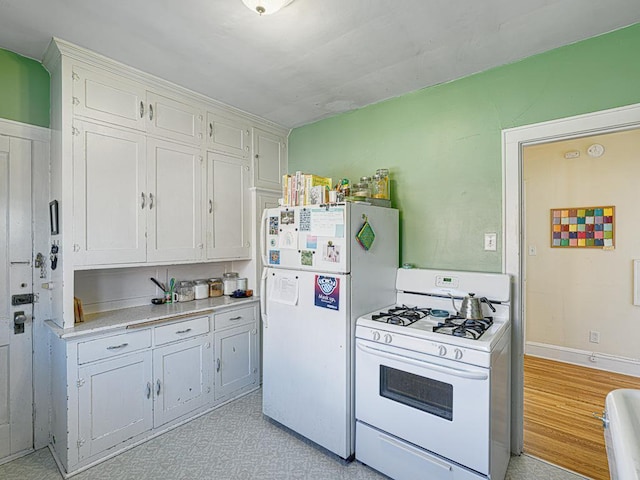 2100 Saint Clair Ave, Saint Paul, MN 55105 - kitchen featuring white appliances, light countertops, white cabinetry, and baseboards