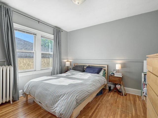 2100 Saint Clair Ave, Saint Paul, MN 55105 - bedroom with wood-type flooring, radiator, and baseboards