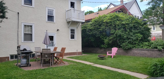 2100 Saint Clair Ave, Saint Paul, MN 55105 - back of house with a fire pit, a balcony, stucco siding, and a lawn