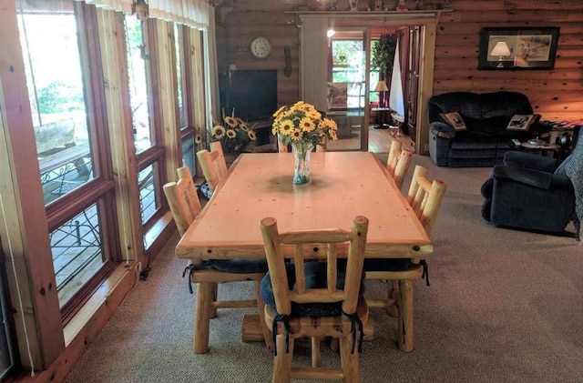 carpeted dining area featuring rustic walls