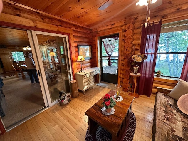 living room with light wood-style flooring, rustic walls, and wood ceiling