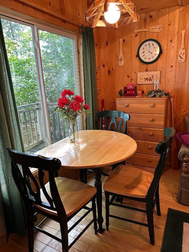 dining area featuring wooden walls and a healthy amount of sunlight