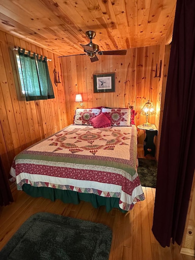 bedroom with wood ceiling, wood walls, and wood finished floors