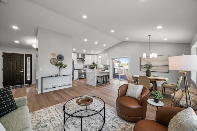 living area with light wood-type flooring, vaulted ceiling, a chandelier, baseboards, and recessed lighting