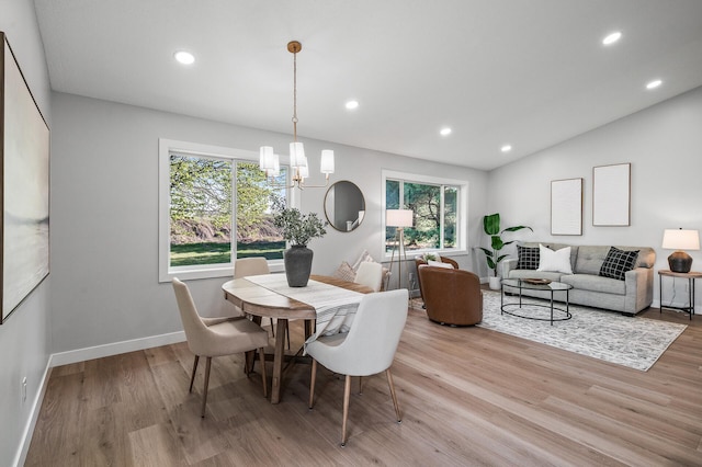 dining area featuring a chandelier, light wood-type flooring, recessed lighting, baseboards, and lofted ceiling