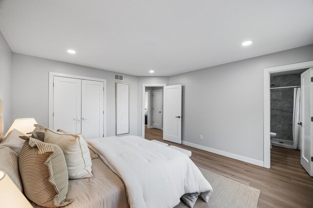 bedroom with wood finished floors, baseboards, recessed lighting, a closet, and ensuite bathroom
