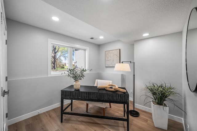 office space with baseboards, wood finished floors, recessed lighting, and a textured ceiling
