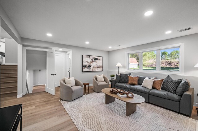 living area featuring stairway, light wood finished floors, recessed lighting, and baseboards