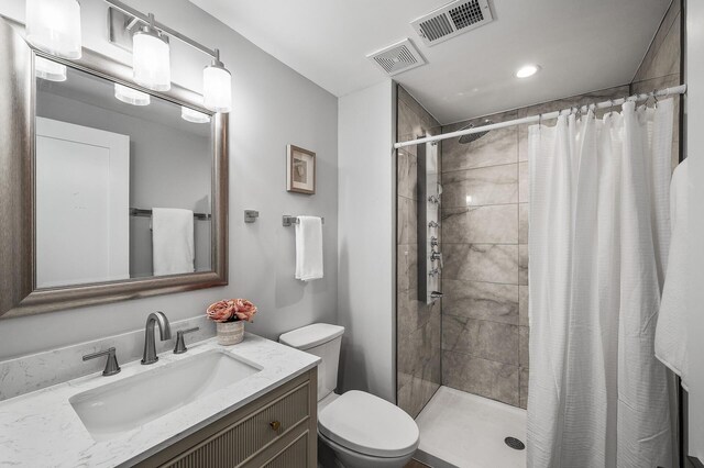 bathroom featuring a stall shower, toilet, vanity, and recessed lighting