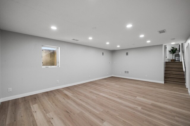 below grade area with stairway, recessed lighting, light wood-style flooring, and baseboards