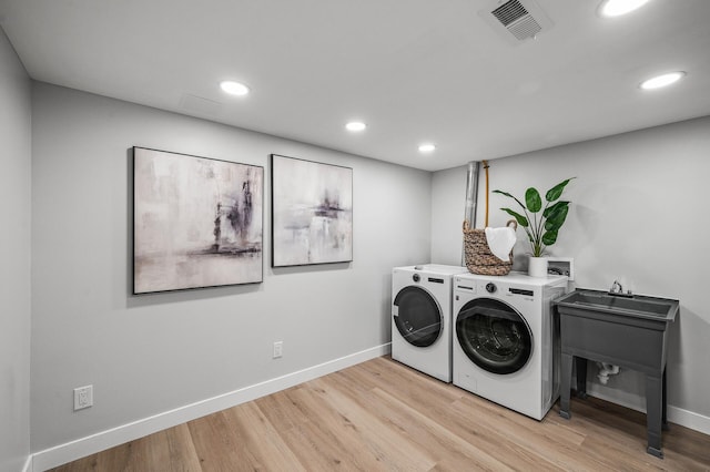 clothes washing area with separate washer and dryer, wood finished floors, baseboards, and recessed lighting