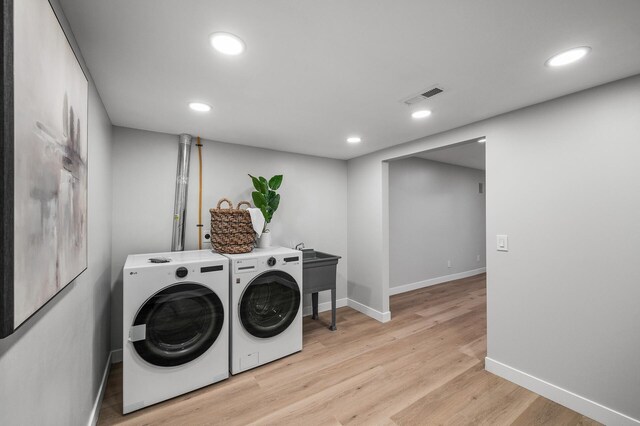 clothes washing area with washing machine and clothes dryer, recessed lighting, light wood-style floors, and baseboards