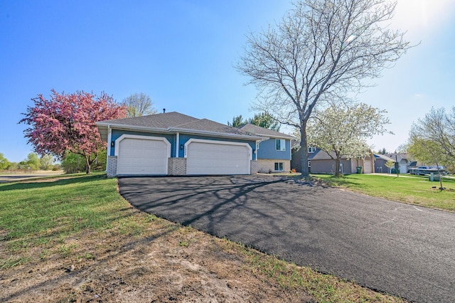 view of property exterior with an attached garage, asphalt driveway, a lawn, and brick siding