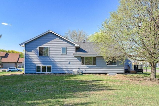 back of house featuring a yard, cooling unit, a shingled roof, and a wooden deck