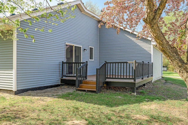 back of property with a yard and a wooden deck