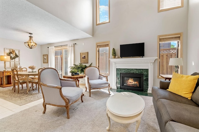 18507 Cherry Tree Ct, Minnetonka, MN 55345 - living room with plenty of natural light, a fireplace, a towering ceiling, a chandelier, and tile patterned flooring