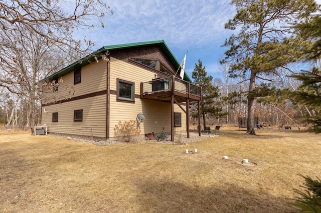 back of house with central AC unit, a wooden deck, and a lawn
