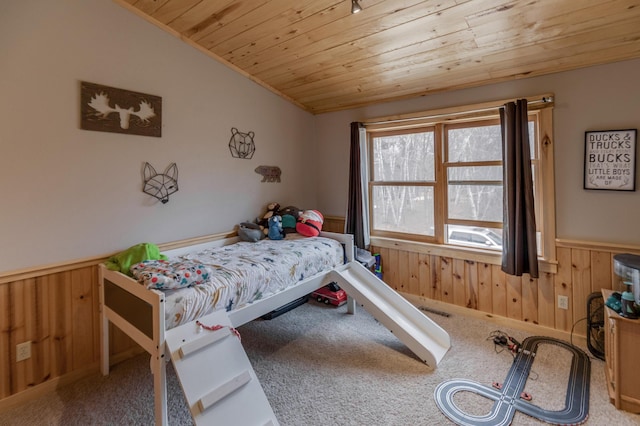 bedroom with wooden ceiling, wainscoting, and carpet flooring