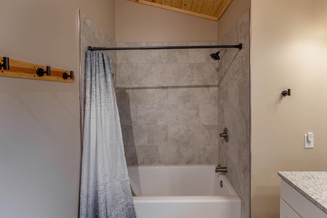 bathroom with shower / bathtub combination with curtain, vaulted ceiling, and vanity
