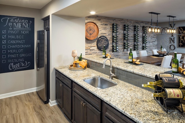14897 144th Ave N, Dayton, MN 55327 - kitchen with a sink, freestanding refrigerator, light wood-style flooring, and light stone counters