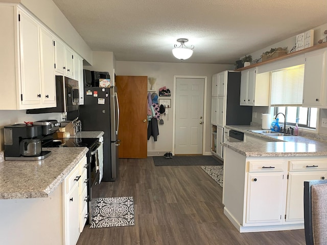 kitchen featuring black electric range, light countertops, a sink, and white cabinetry
