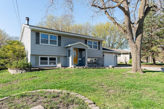 bi-level home featuring a garage, a front yard, and driveway
