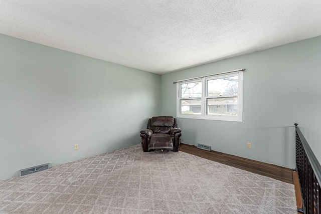 unfurnished room featuring wood finished floors and a textured ceiling