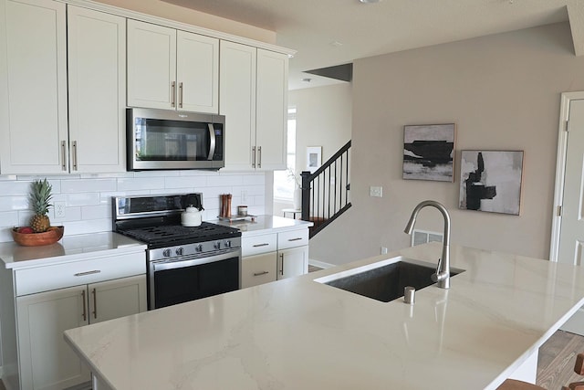 5275 94th Ln N, Brooklyn Park, MN 55443 - kitchen featuring light stone countertops, a sink, backsplash, stainless steel appliances, and a kitchen island with sink