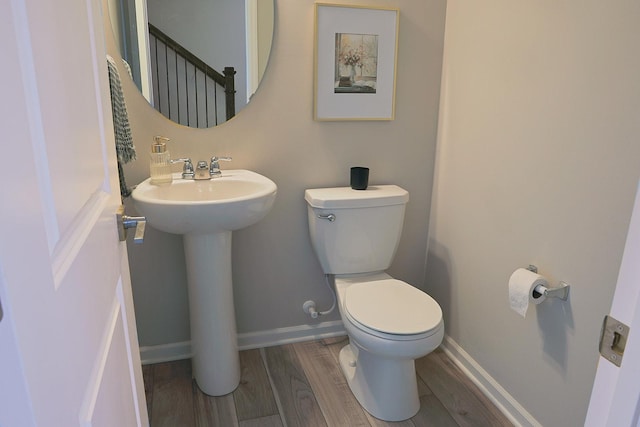 5275 94th Ln N, Brooklyn Park, MN 55443 - half bathroom featuring a sink, toilet, baseboards, and wood finished floors