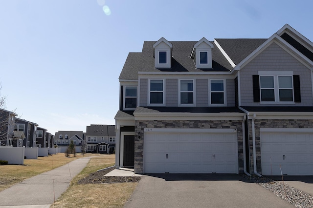 5275 94th Ln N, Brooklyn Park, MN 55443 - townhome / multi-family property featuring an attached garage, roof with shingles, stone siding, and aphalt driveway