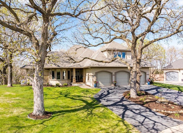2222 White Oak Ct, Hudson, WI 54016 - view of front of house featuring a garage, stucco siding, driveway, and a front lawn