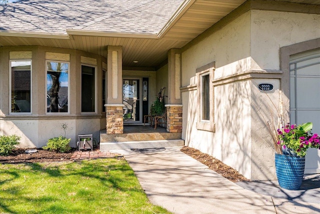 2222 White Oak Ct, Hudson, WI 54016 - doorway to property featuring a shingled roof, a porch, stone siding, and stucco siding