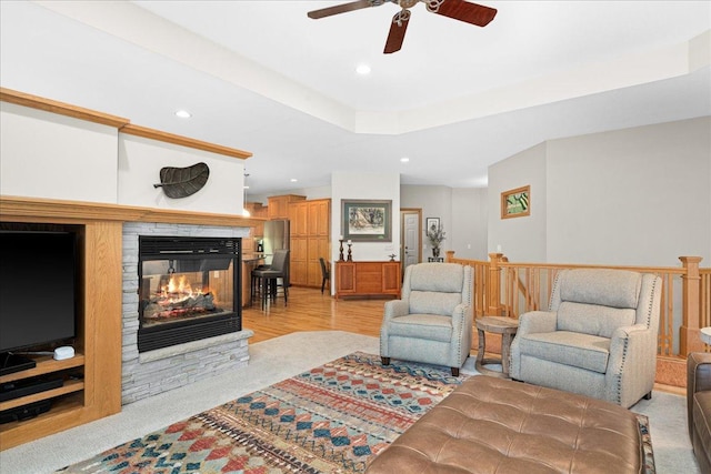 2222 White Oak Ct, Hudson, WI 54016 - living room featuring recessed lighting, a ceiling fan, a fireplace, light wood-style flooring, and a raised ceiling