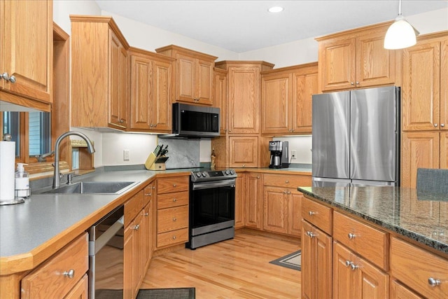 2222 White Oak Ct, Hudson, WI 54016 - kitchen with appliances with stainless steel finishes, light wood-style floors, decorative light fixtures, brown cabinets, and recessed lighting